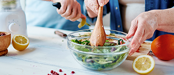 Two people preparing a salad